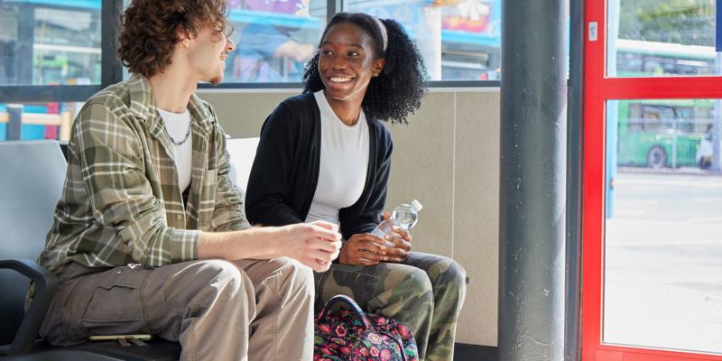 Two Young People Sat Talking In Leeds Bus Station