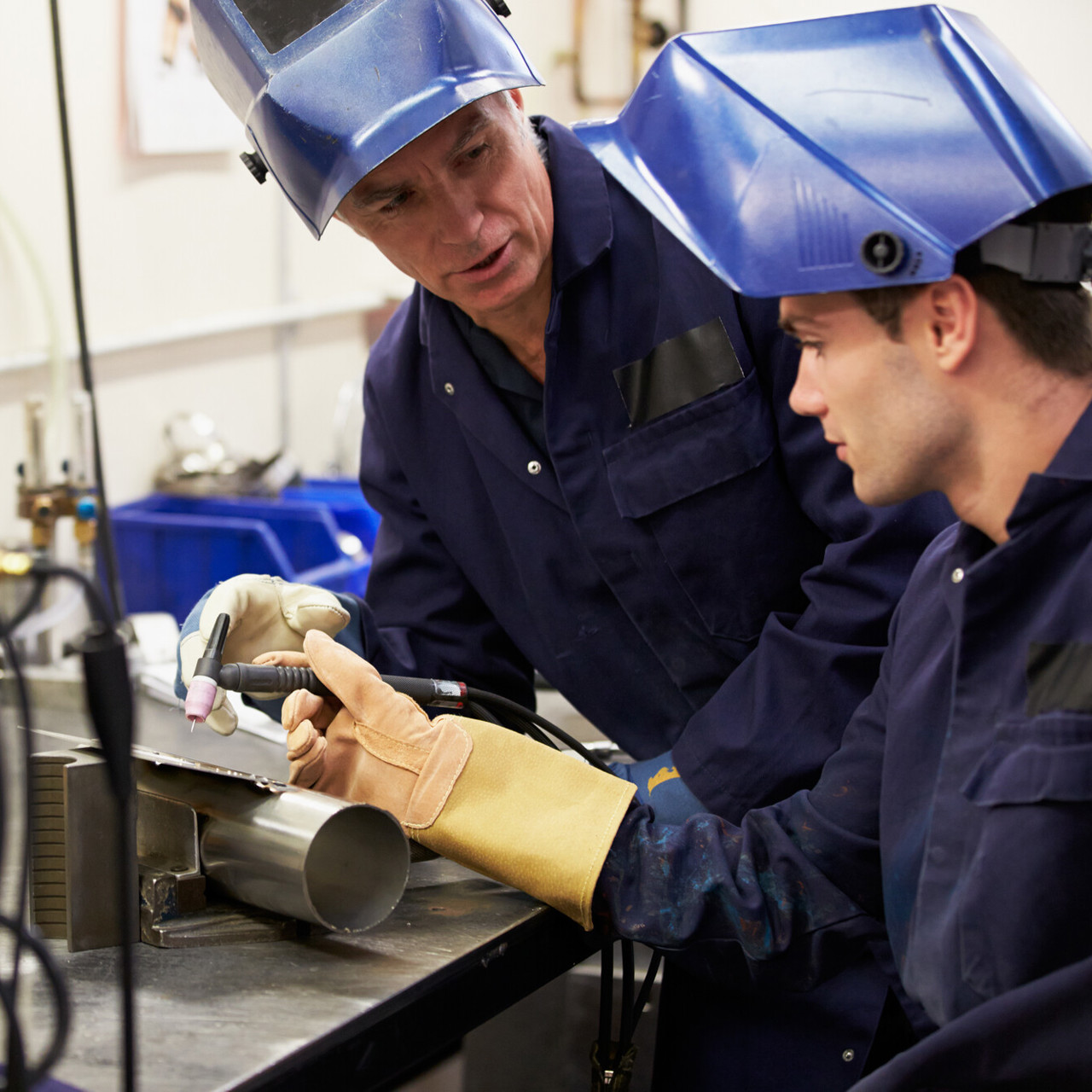 Engineer Teaching Apprentice To Use Welding Machine