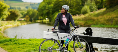 Woman stands next to bike by canal in West Yorkshire