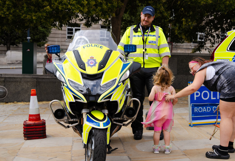 Family speaking to a police officer stood next to a police bike