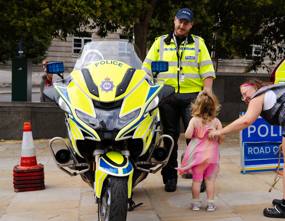 Family speaking to a police officer stood next to a police bike