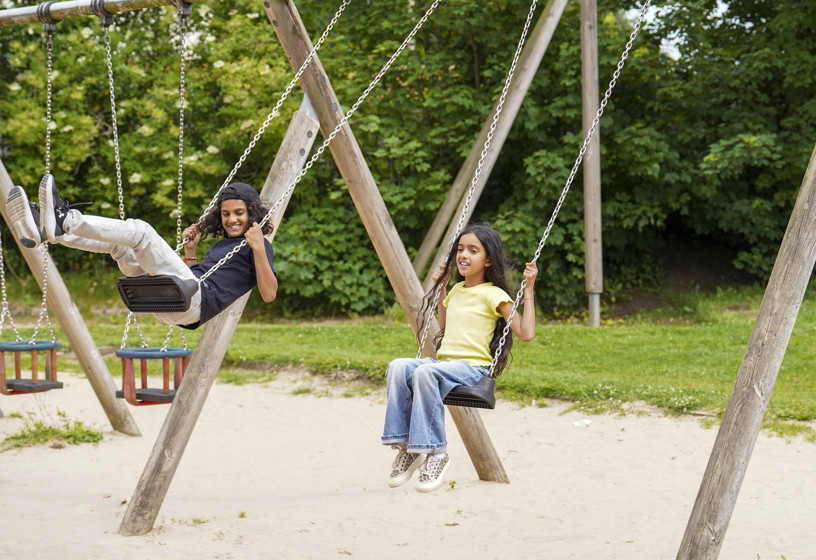 Two children on swings in a park