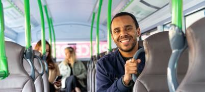 Man sitting on a bus smiling