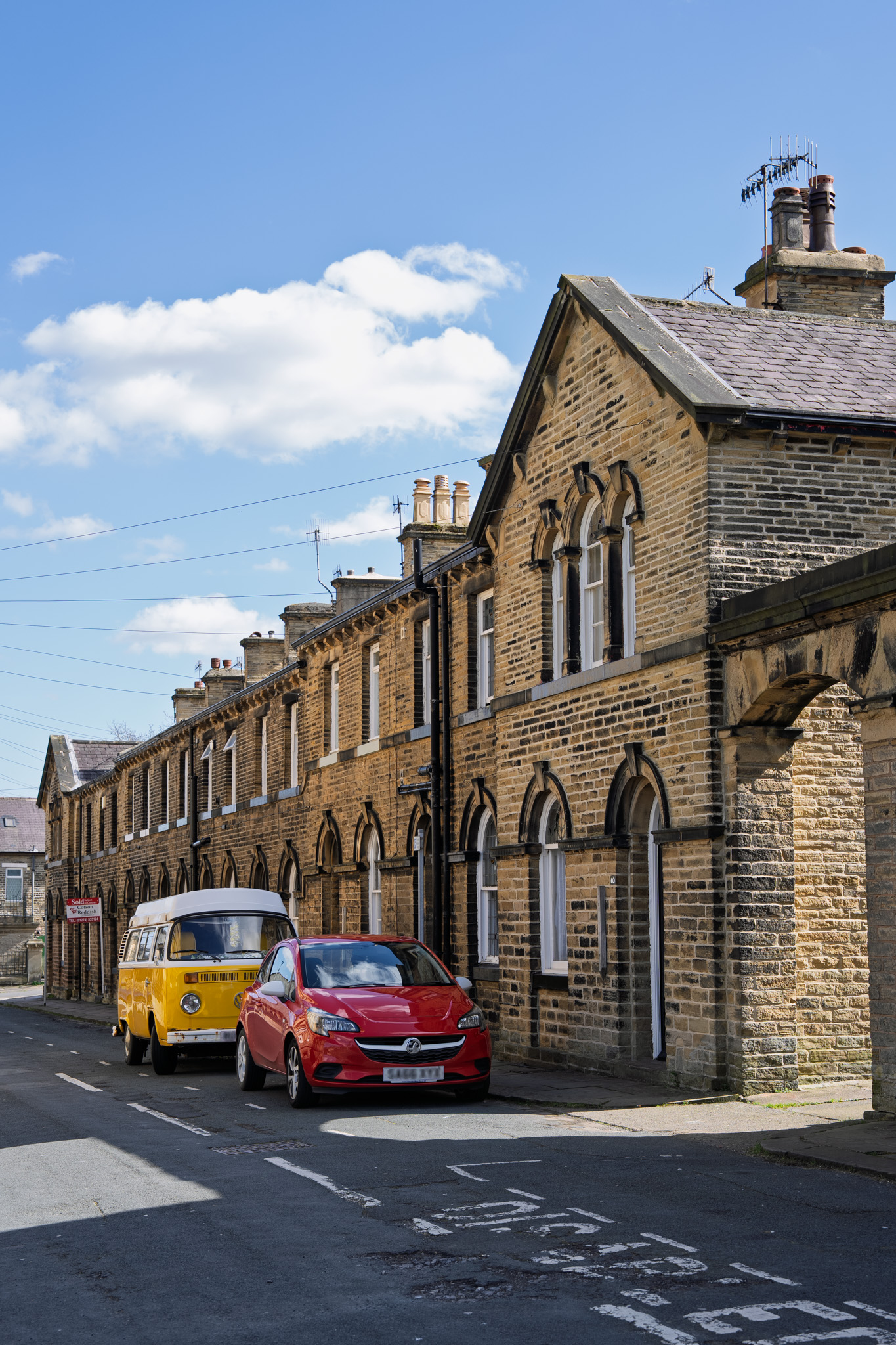 A street in Saltaire with a car and campervan outside