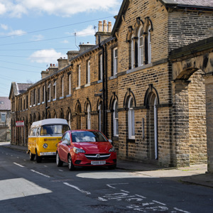 A street in Saltaire with a car and campervan outside