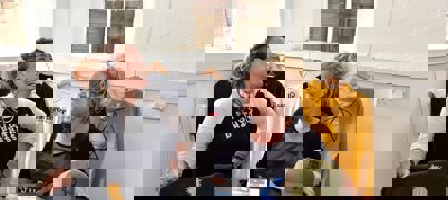 Two ladies laughing with a range of printed merchandise in front of them