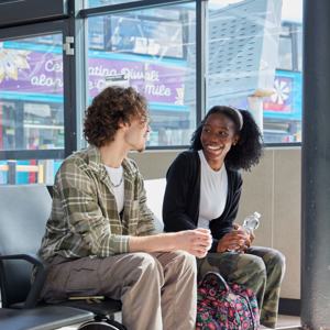 Two Young People Sat Talking In Leeds Bus Station