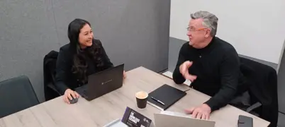 Two people sat in a meeting room, having a conversation