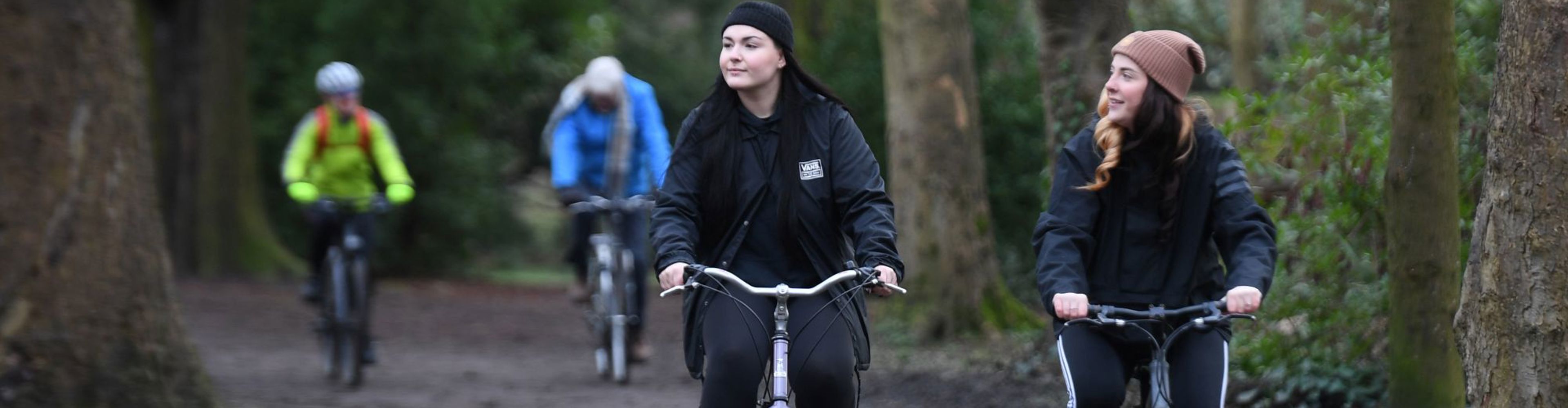 2 Women Riding Bikes In Woodland In Wakefield