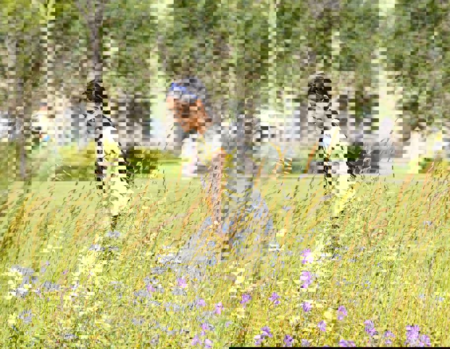 Girl walking beside wildflowers in garden in Bradford