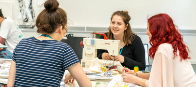 Students sewing together at table 