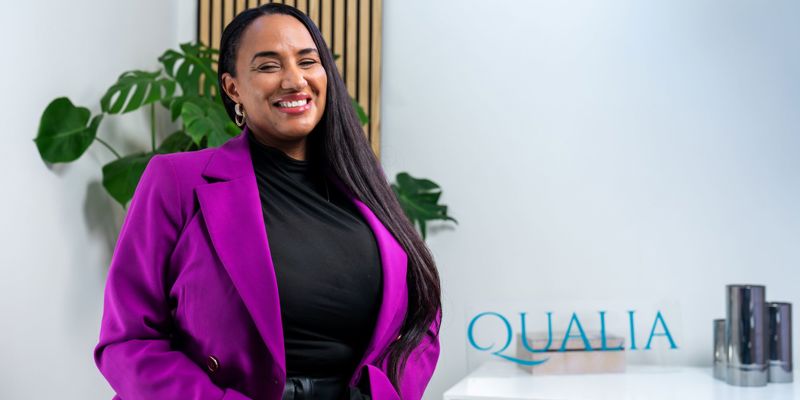A woman in a pink blazer, smiling