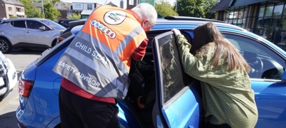Man checking a child car seat is installed safely
